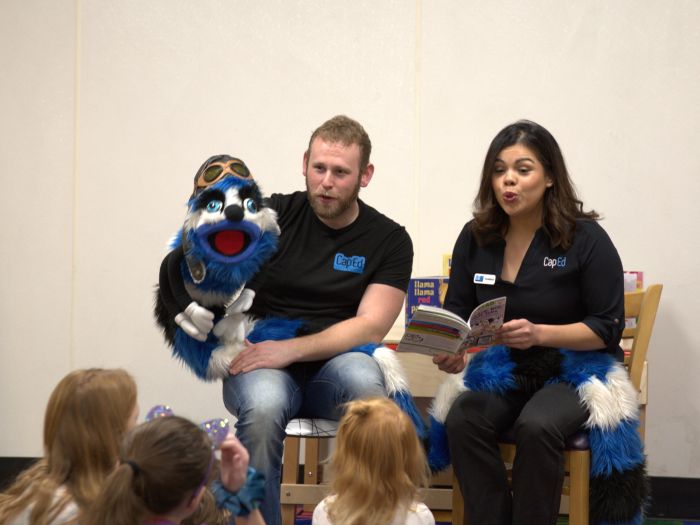 CapEd Brand Engagement specialists and Ed Word the Bookworm reading a book to a classroom of students.